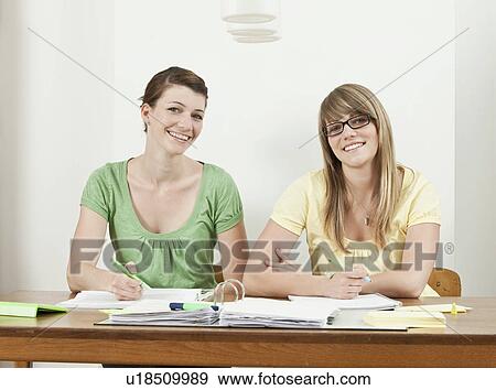 Two students sitting at table View Large Photo Image Stock Photo - Two students sitting at table. Fotosearch