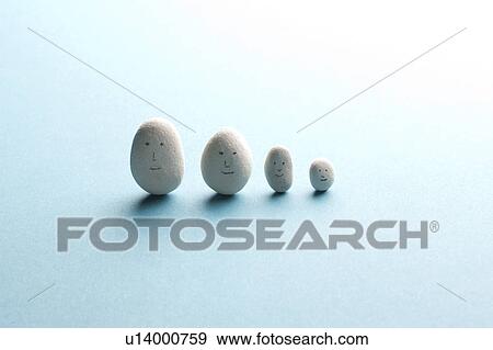 Stock Photo - White stones with faces drawn on them. Fotosearch