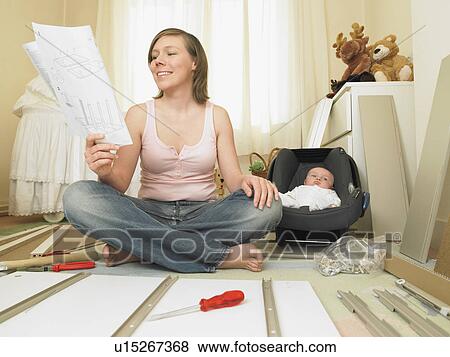 Stock Photo - Woman and baby building furniture. Fotosearch