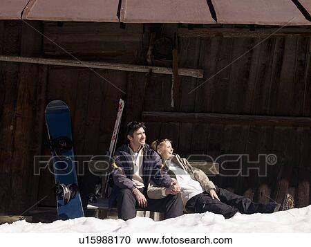 Stock Image - woman and man relaxing by hut. Fotosearch