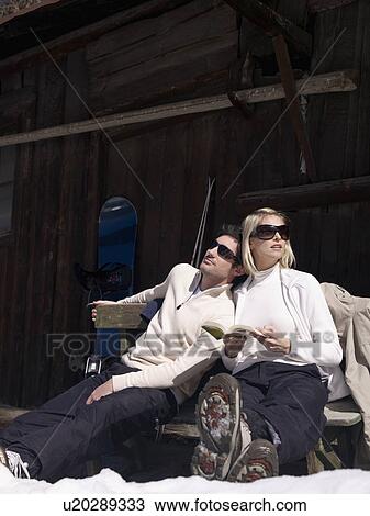 Stock Image - woman and man relaxing by hut. Fotosearch