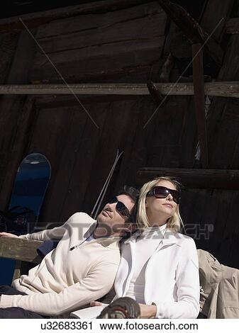 Stock Image - woman and man relaxing by hut. Fotosearch