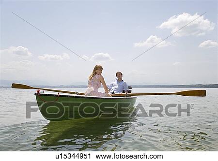 Stock Image - woman and man rowing boat on lake. Fotosearch