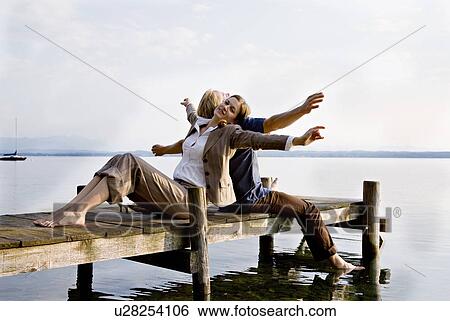 woman and man sitting on pier at lake View Large Photo Image Stock Photograph - woman and man sitting on pier at lake. Fotosearch