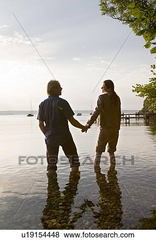 Stock Photo - woman and man standing in lake. Fotosearch