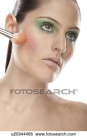 Woman applying blusher to her cheeks View Large Photo Image Stock Photography - Woman applying blusher to her cheeks. Fotosearch