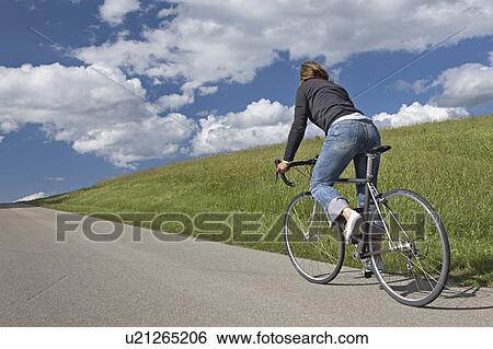 Stock Photograph - Woman bicycling in the countryside. Fotosearch