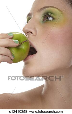 Woman biting into green apple View Large Photo Image Stock Photo - Woman biting into green apple. Fotosearch
