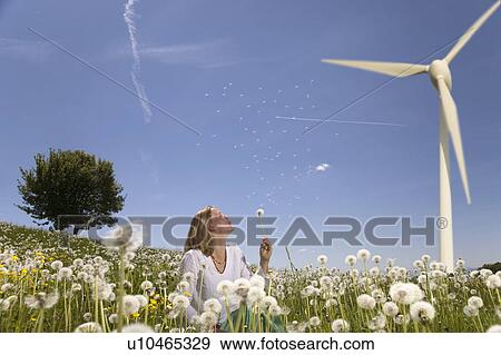 woman blowing dandelion at wind turbine View Large Photo Image Stock Photo - woman blowing dandelion at wind turbine. Fotosearch