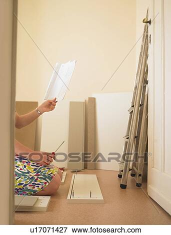 Stock Photo - Woman building chest of drawers. Fotosearch