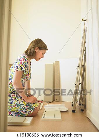 Stock Photography - Woman building chest of drawers. Fotosearch