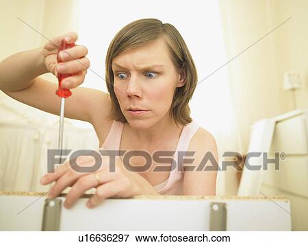 Stock Photo - Woman building furniture. Fotosearch
