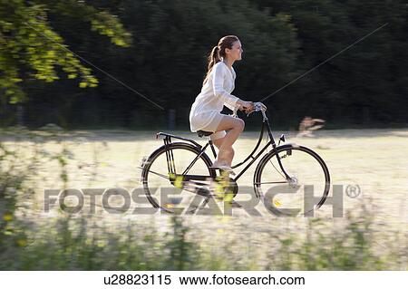 Woman cycling through countryside View Large Photo Image Stock Photography - Woman cycling through countryside. Fotosearch