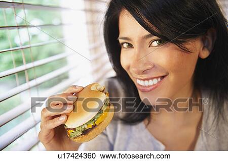 Stock Image - Woman eating a burger. Fotosearch