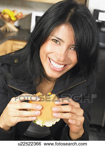 Woman eating a burger View Large Photo Image Stock Photograph - Woman eating a burger. Fotosearch