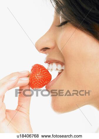 Woman eating a strawberry View Large Photo Image Stock Photo - Woman eating a strawberry. Fotosearch