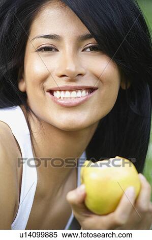 Woman eating an apple, smiling View Large Photo Image Stock Photography - Woman eating an apple, smiling. Fotosearch