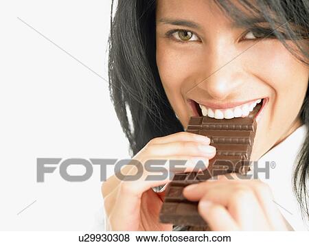 Woman eating chocolate View Large Photo Image Stock Photo - Woman eating chocolate. Fotosearch