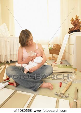 Stock Photo - Woman feeding baby. Fotosearch