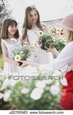 Stock Image - woman gardening with two children. Fotosearch