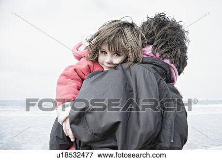 Stock Photo - Woman holding child on beach. Fotosearch