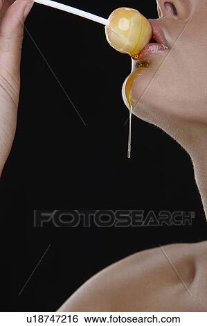 Woman holding honey lollipop to her lips View Large Photo Image Stock Photograph - Woman holding honey lollipop to her lips. Fotosearch