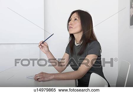 woman holding pencil, looking up View Large Photo Image Stock Photography - woman holding pencil, looking up. Fotosearch