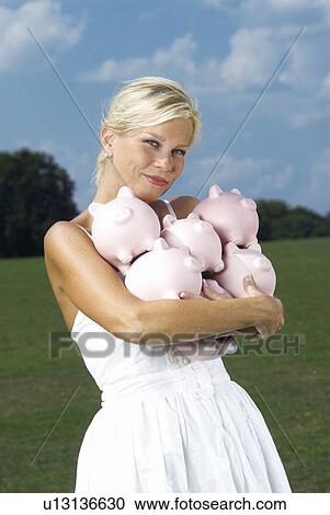 Stock Image - woman holding piggy banks. Fotosearch