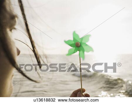 Woman holding windmill towards sea View Large Photo Image Stock Image - Woman holding windmill towards sea. Fotosearch