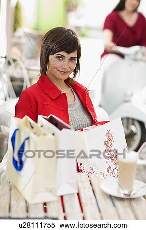 Stock Photography - woman in a street cafe after shopping. Fotosearch