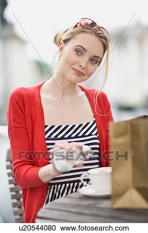 Stock Image - woman in a street cafe glancing at s. o.. Fotosearch
