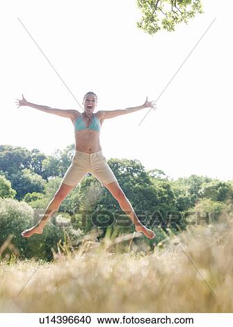 Woman in bikini jumping in country field View Large Photo Image Stock Image - Woman in bikini jumping in country field. Fotosearch