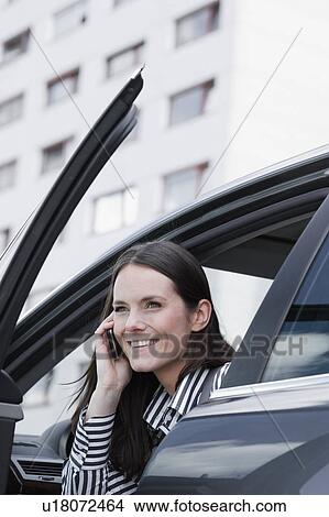 Picture - woman in car on phone. Fotosearch