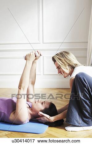 Woman instructing a client. Pilates. View Large Photo Image Stock Photo - Woman instructing a client. Pilates.. Fotosearch