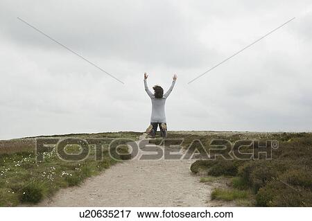 Woman jumping on path in moors View Large Photo Image Stock Photo - Woman jumping on path in moors. Fotosearch