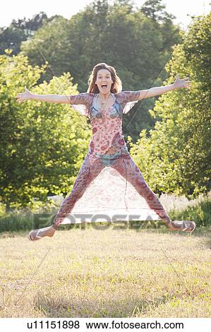 Woman jumping with joy in country View Large Photo Image Stock Photo - Woman jumping with joy in country. Fotosearch