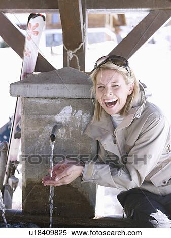 Stock Photography - woman laughing by fountain. Fotosearch