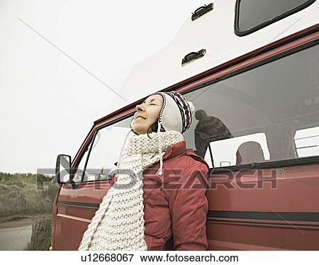 Stock Photo - Woman leaning against van. Fotosearch
