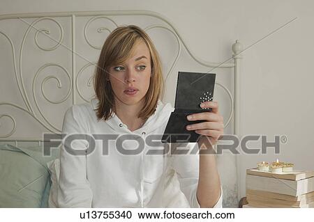 Stock Image - Woman looking in mirror. Fotosearch