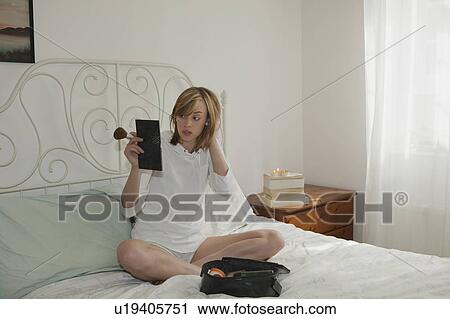 Stock Image - Woman looking in mirror. Fotosearch