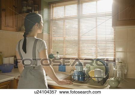 Woman looking out of a window View Large Photo Image Stock Photo - Woman looking out of a window. Fotosearch