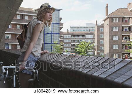 Stock Photo - Woman looking over balcony. Fotosearch