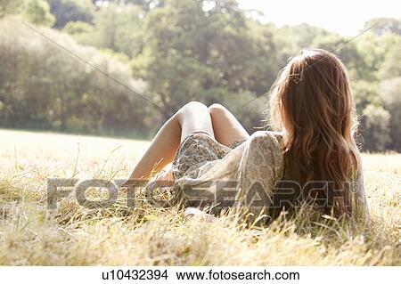 Woman lying in countryside field View Large Photo Image Picture - Woman lying in countryside field. Fotosearch