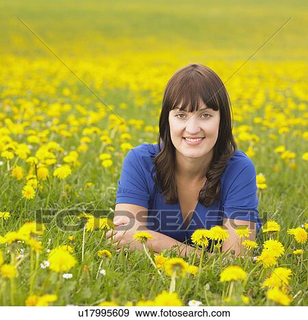 Stock Photo - Woman lying on meadow. Fotosearch