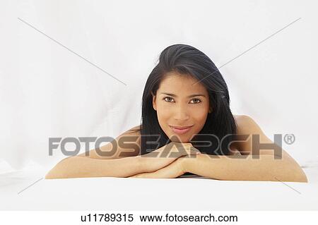 Stock Photography - Woman on a bed, smiling. Fotosearch