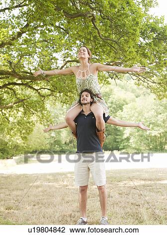 woman on mans shoulders under tree View Large Photo Image Stock Image - woman on mans shoulders under tree. Fotosearch