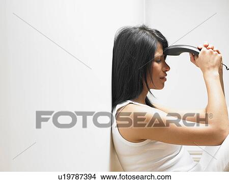 Picture - Woman on the phone, anxious. Fotosearch