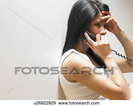 Stock Photo - Woman on the phone, anxious. Fotosearch