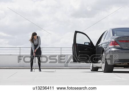 woman playing golf near car View Large Photo Image Stock Image - woman playing golf near car. Fotosearch