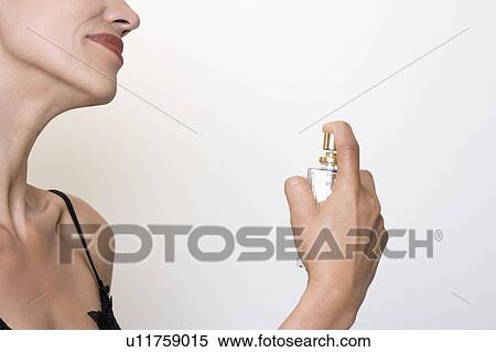 woman putting some perfume on her View Large Photo Image Stock Photography - woman putting some perfume on her. Fotosearch